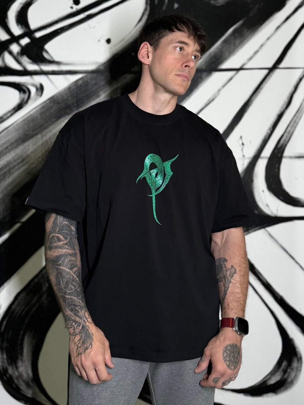 OverPower Strength Wear black oversized t-shirt worn, front view with the green OP monogram