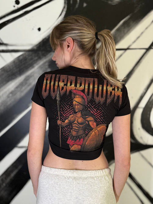 OverPower Strength Wear black crop tee worn, back view: Athena with helmet, spear and shield over a labyrinth pattern, copper OverPower lettering