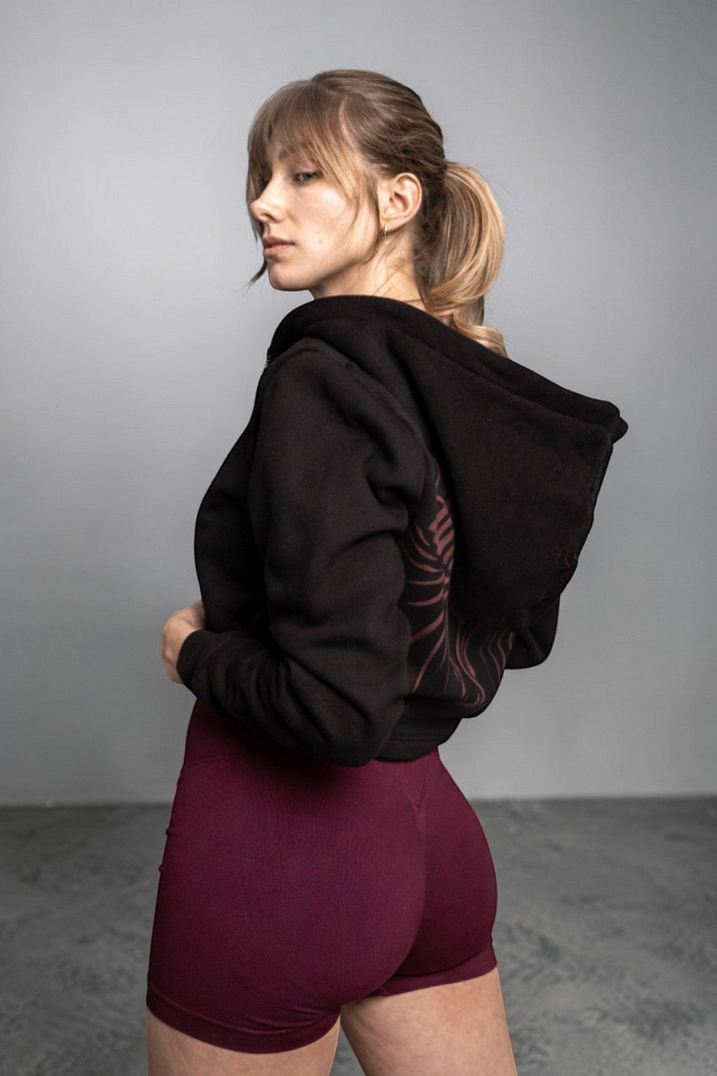 OverPower Strength Wear black cotton fleece crop zip-up hoodie with graphic detail on back.