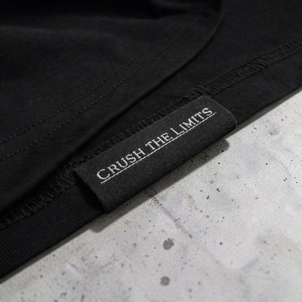 OverPower Strength Wear black oversized heavyweight cotton tee with "CRUSH THE LIMITS" woven label.
