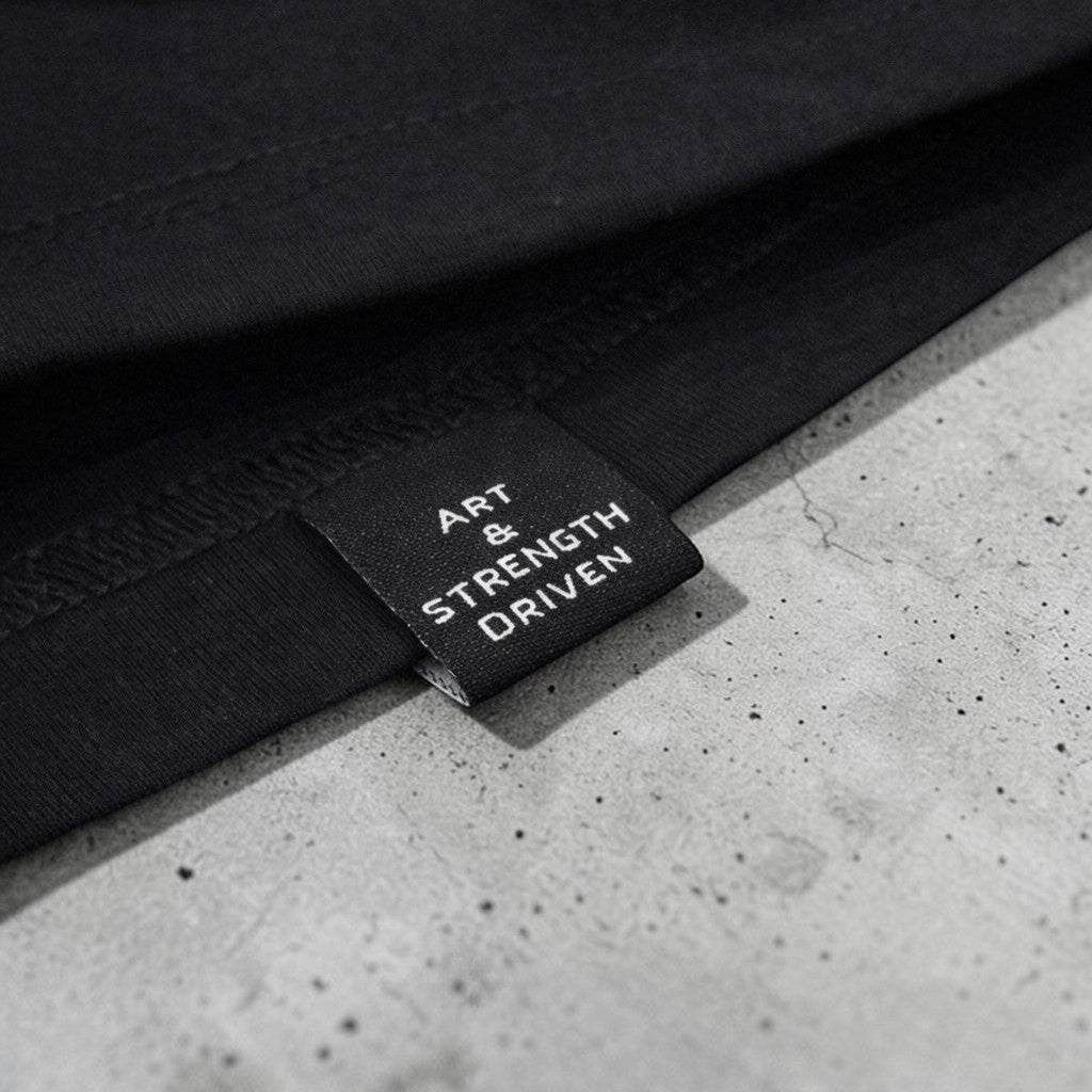 OverPower Strength Wear Black Widow oversized tee, premium heavyweight cotton with "ART & STRENGTH DRIVEN" label.